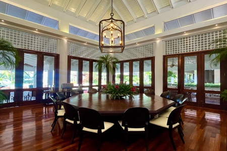 Elegant dining area with a large round table and stunning views of the outdoors.