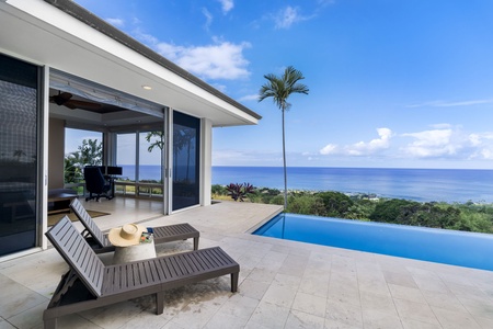 Modern tropical villa with infinity pool and stunning ocean views surrounded by lush greenery.