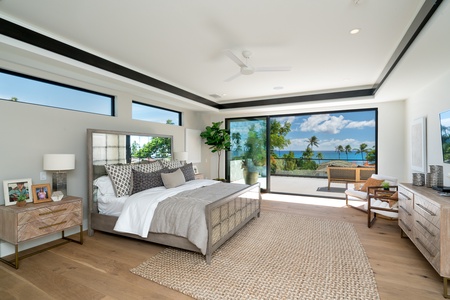 The primary bedroom features a king bed and breathtaking ocean views, making it a tranquil escape on your Hawaiian getaway.