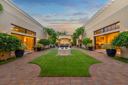 Serene courtyard with a central fountain, lush landscaping, and sunset views for a tranquil ambiance.