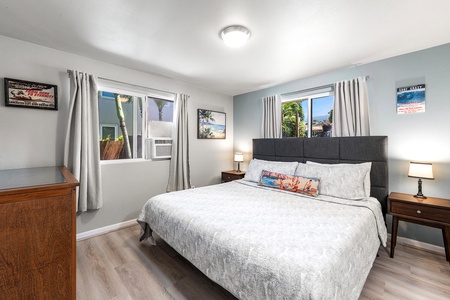 Bright and airy bedroom with king bed and windows framing tropical garden views.