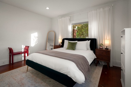 Enjoy quiet evenings in this cozy bedroom with warm wood floors and filtered sunlight.