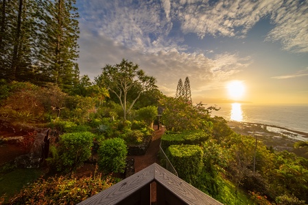 Stunning coastal property surrounded by lush tropical gardens, offering spectacular sunset views over the ocean horizon.