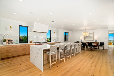 Modern luxury home featuring premium outdoor entertaining spaces with swimming pool, hot tub, elegant fire pit seating, and contemporary architecture at twilight.
