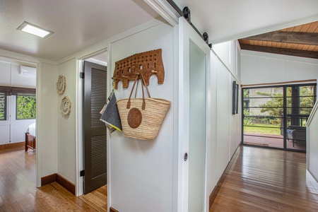 Modern barn door adds a sleek, island-chic touch to this stylish hallway space.