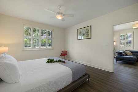 Rest peacefully in your serene bedroom with natural light streaming through large windows and a ceiling fan for comfort.