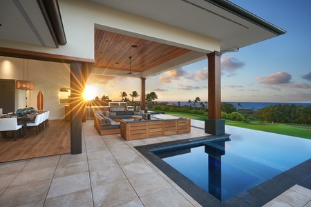 Enjoy the modern outdoor lanai with sunset views, an infinity pool, and a cozy seating area.