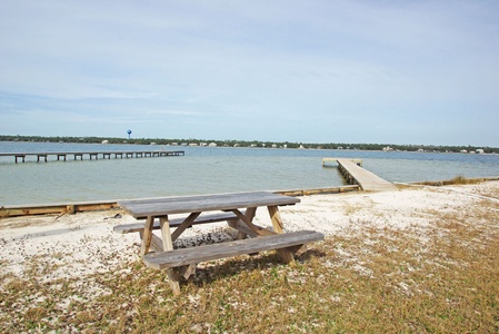 Sandy beach area with a picnic table and lagoon access