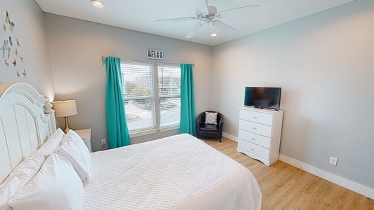 Bedroom 2 has a ceiling fan and a TV