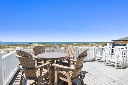 Expansive uncovered porch with table and rocking chairs