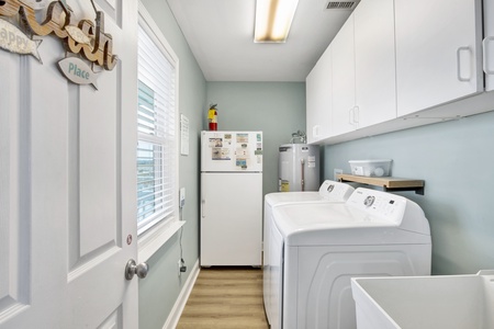 Laundry room with an extra fridge, laundry sink and washer/dryer