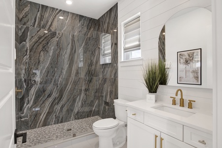 The private bathroom features a walk-in tile shower