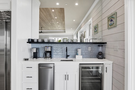 The wet bar features a sink, ice maker and wine cooler