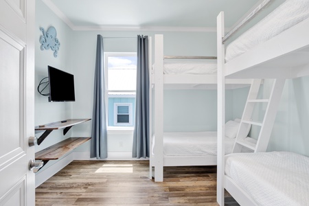 Bedroom 4 offers 2 sets of twin bunk beds, a TV and attached, shared bathroom