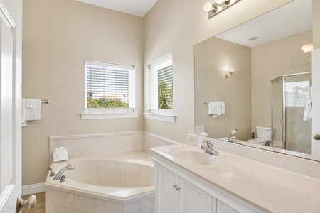 The private bathroom features dual vanities and jetted tub
