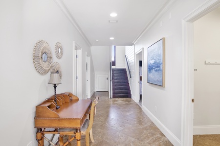 1st floor hallway with a desk and stairs that lead to the 2nd floor