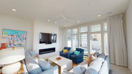 The comfortable open living area features plush seating, large mounted TV and a gas fireplace