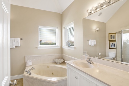 The private en suite features dual vanities and jetted tub