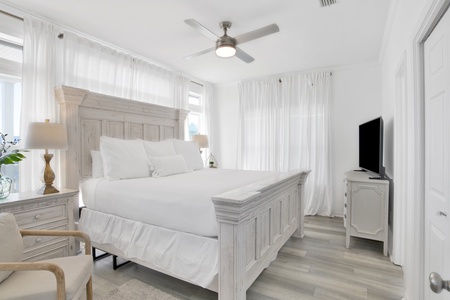 The 1st floor master bedroom has a king bed, TV, lagoon views and a private bath