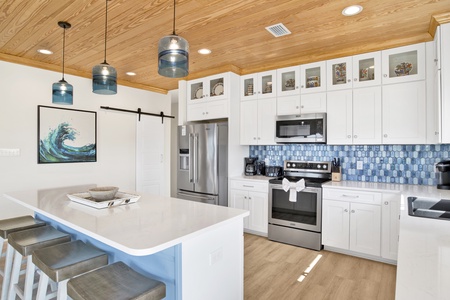 Bright and open kitchen with stainless appliances, tile backsplash and quartz countertops