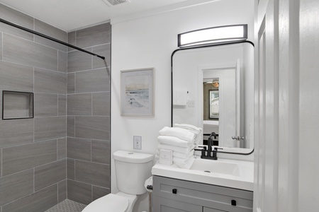 The hallway bathroom features a walk-in tile shower