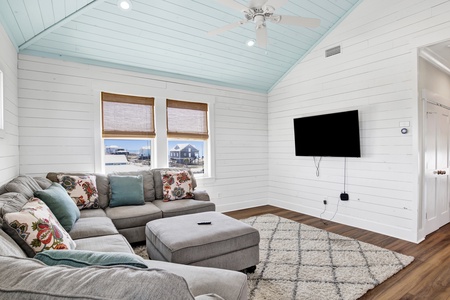The 2nd floor living room has a large sectional and flatscreen TV
