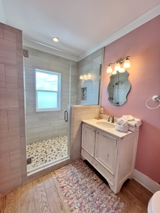 The private bathroom features a walk-in tile shower