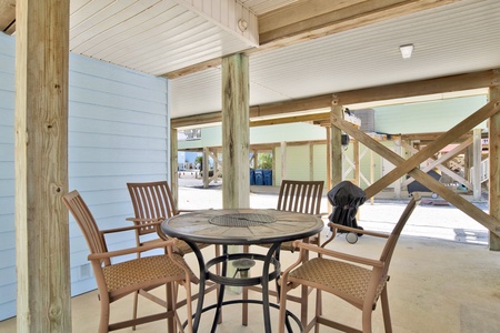 Charcoal grill and dining area under the home