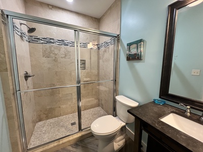 1st floor bathroom with tile shower, located in hallway