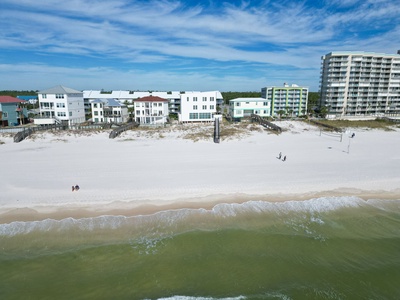 Expansive white sandy beach area in front of the home