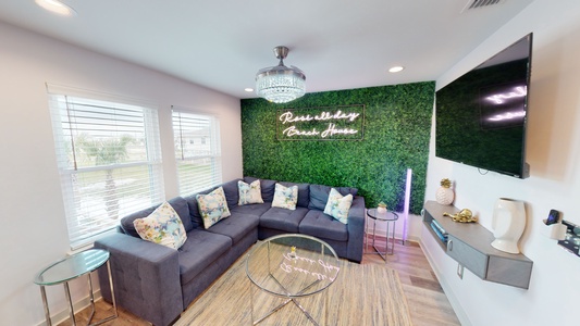 Open living area with a large sectional and mounted television