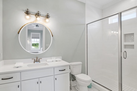 The guest bathroom features a walk-in, tile shower