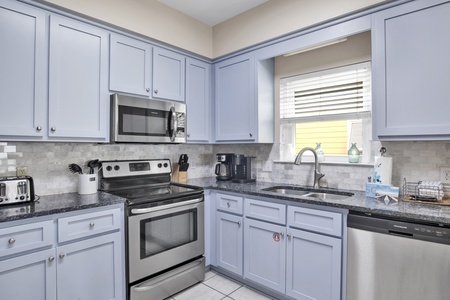 Updated kitchen with stainless appliances, granite and tile backsplash