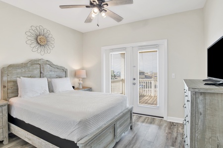 Upstairs bedroom 3 with a queen bed, balcony access and a TV