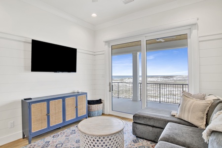 The 2nd floor living room offers a sectional sofa and TV