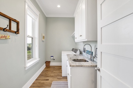 The laundry room provides a full size washer and dryer and a sink