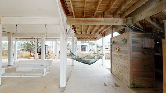 Hammock, swing and lounging area under home