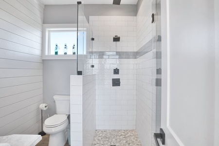 There is a custom tiled walk-in shower