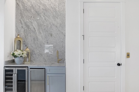 Private wet bar with sink, ice maker and wine cooler - next to the elevator on the main floor