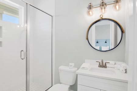 The guest bathroom features a walk-in, tile shower