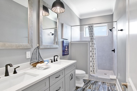 Guest bathroom located in hallway with double vanities and walk in shower