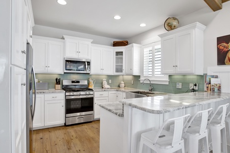 Gas stove, stainless appliances, tile backsplash and granite countertops