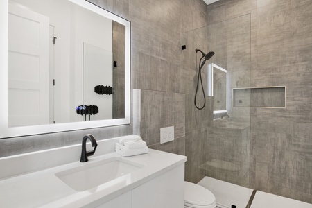 The private bathroom offers a walk-in tile shower