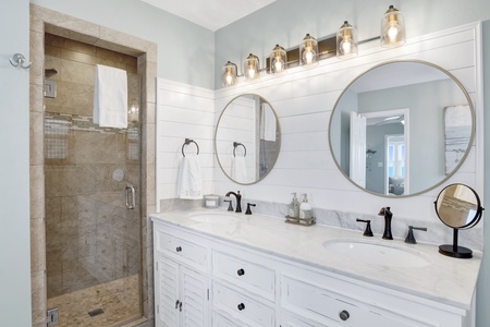 The master bathroom features a full size tub and walk-in shower, with a double vanity.