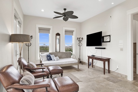 The master bedroom has a TV, lounge area, daybed, lagoon views and balcony access