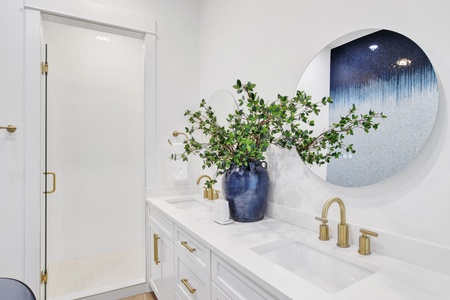 The private bathroom has dual vanities and a walk-in tile shower