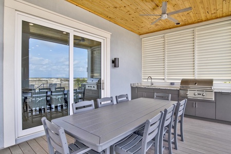 Custom outdoor kitchen equipped with grill, sink and outdoor dining