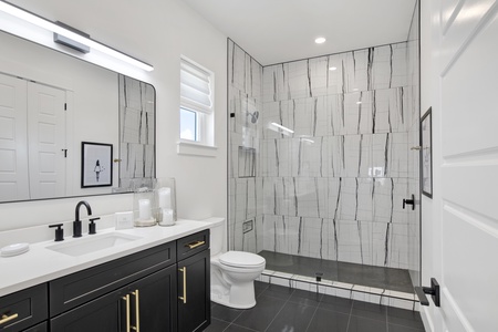 The private bathroom features a walk-in tile shower
