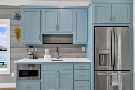 The kitchenette features a full size fridge, sink and microwave