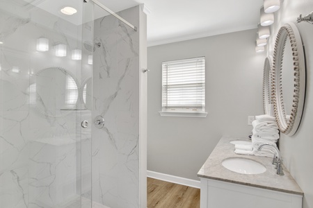 The shared bathroom features double vanities and a walk-in shower. It's also accessible from the hallway